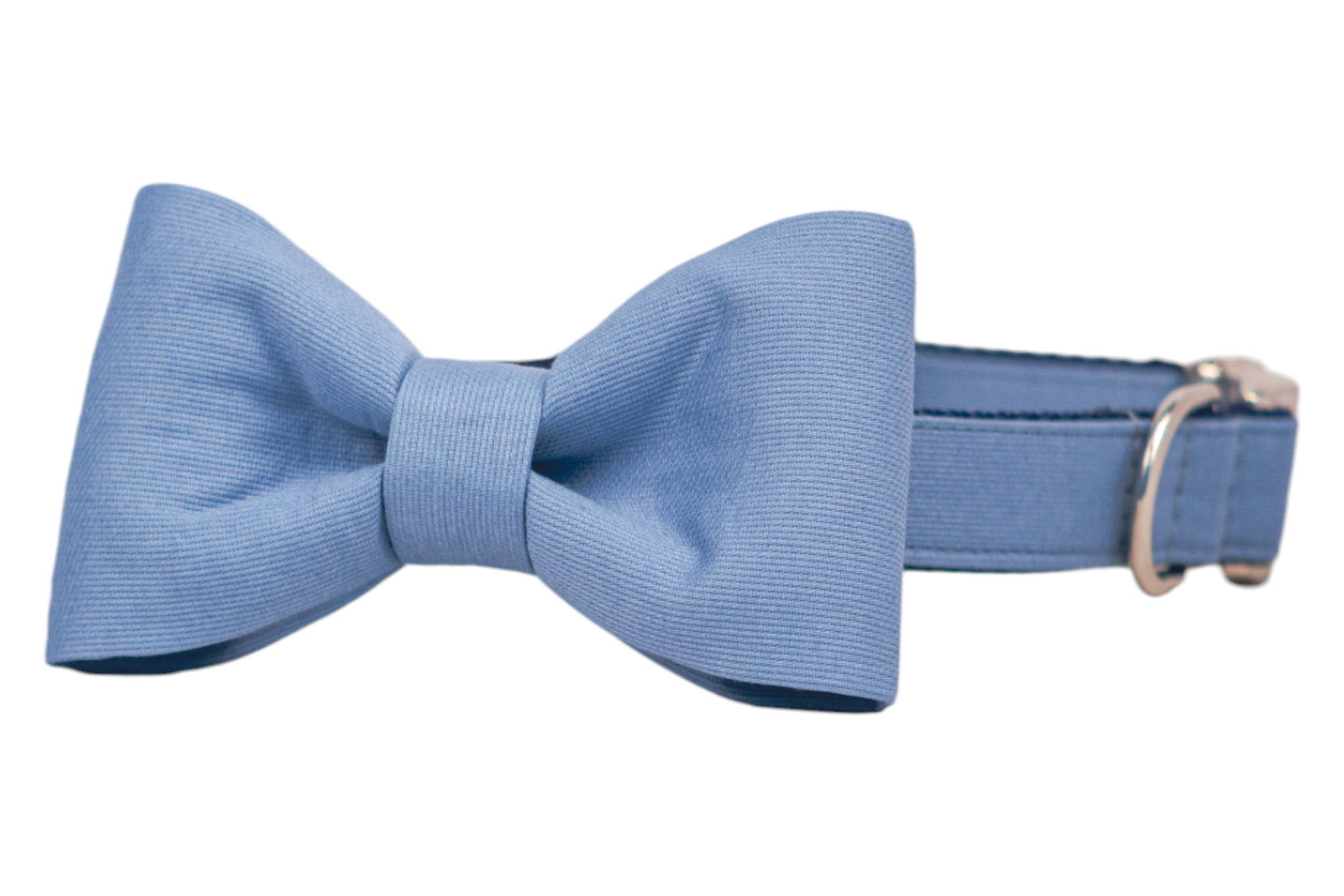 A slate blue dog collar featuring an attached matching bow tie made from ribbed fabric, giving it a soft texture and subtle sheen. The symmetrical bow is centered on the collar, which includes a polished silver D-ring and adjustable strap for fit and function.
