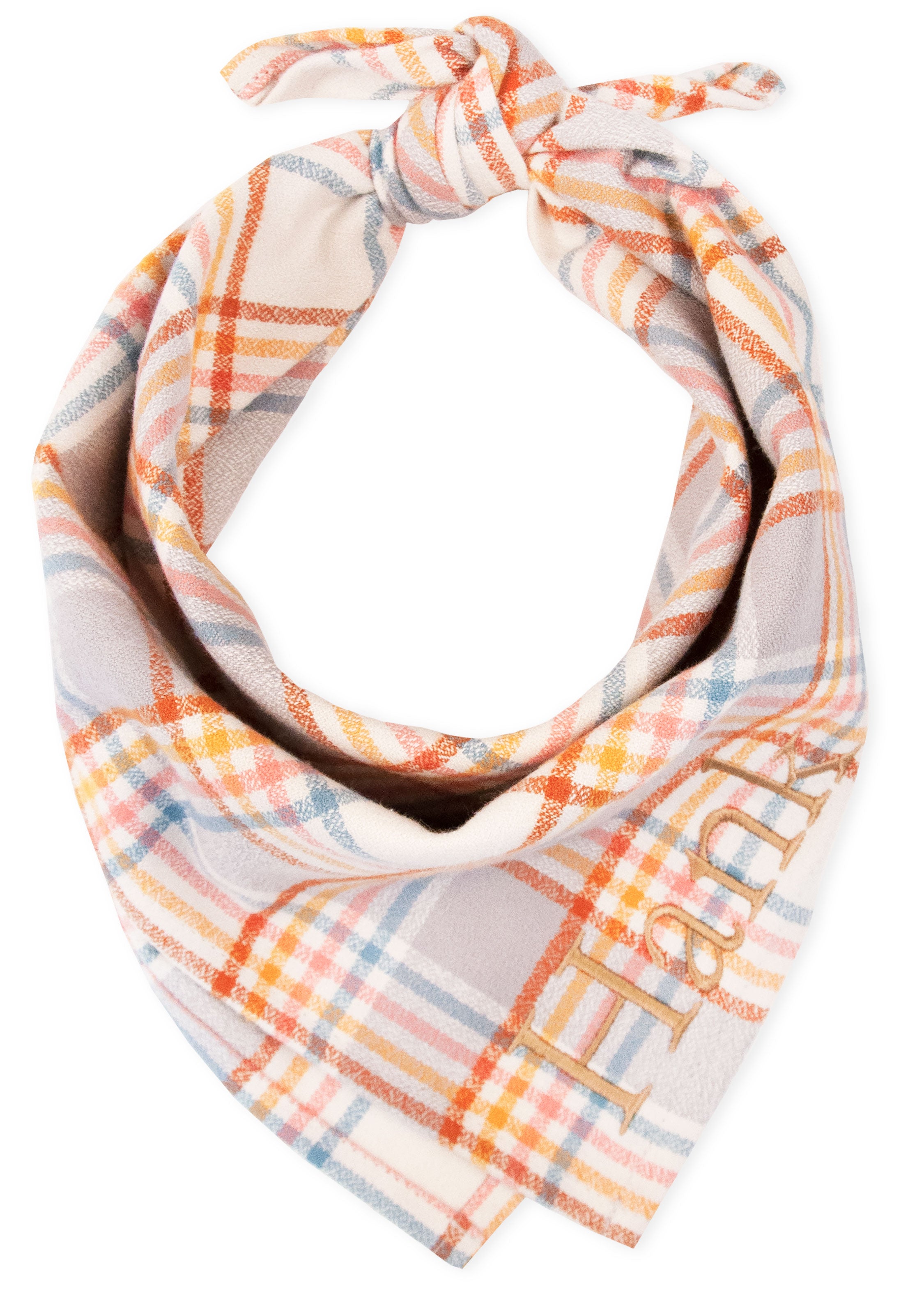 Close-up of a custom plaid dog bandana featuring soft flannel fabric with a light beige base and intersecting lines in warm and cool pastel shades. The bandana is tied into a knot and embroidered with the name “Hank” in tan-colored thread on one side.