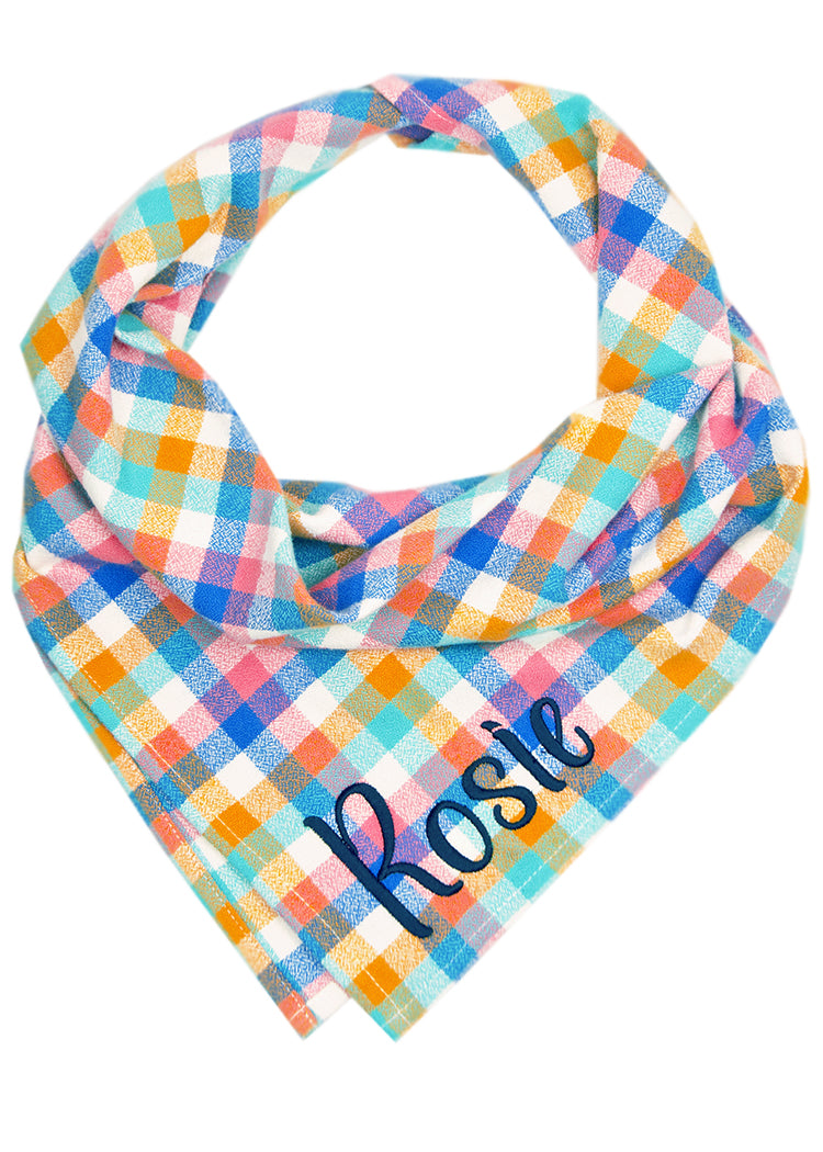 A vibrant pastel plaid dog bandana with overlapping squares in candy-colored hues — perfect for turning every outing into a photo-worthy moment. The name "Rosie" is embroidered on the bottom right.