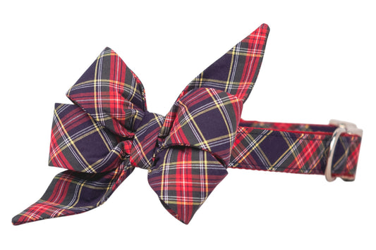 Festive red and navy tartan bow with long tapered ends, secured to a coordinating plaid dog collar fitted with a metal buckle.