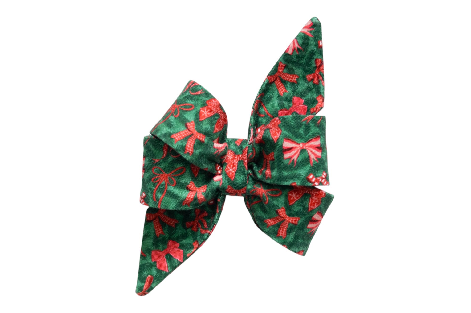 Large decorative dog belle bow made from green fabric printed with bows, gingham ribbon designs, and candy canes. The feminine belle bow features exaggerated, pointed tails and layered loops, creating a dramatic holiday look, ideal for attaching onto a collar as a festive accessory.