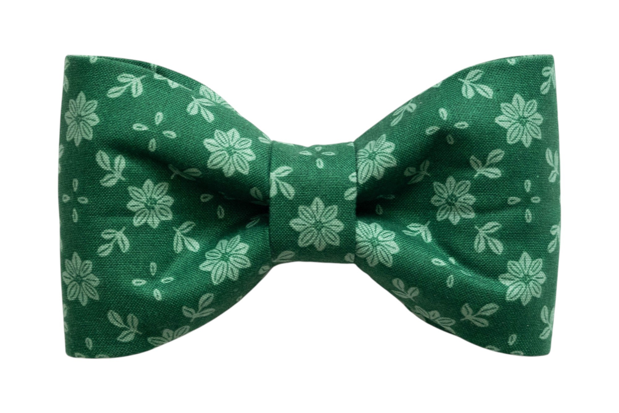 A classic dog bow tie made from green fabric with a light green floral pattern featuring symmetrical flowers and scattered leaf shapes. The bow tie has a crisp, structured shape with a cinched center and is designed to attach to a collar for a simple, elegant look.