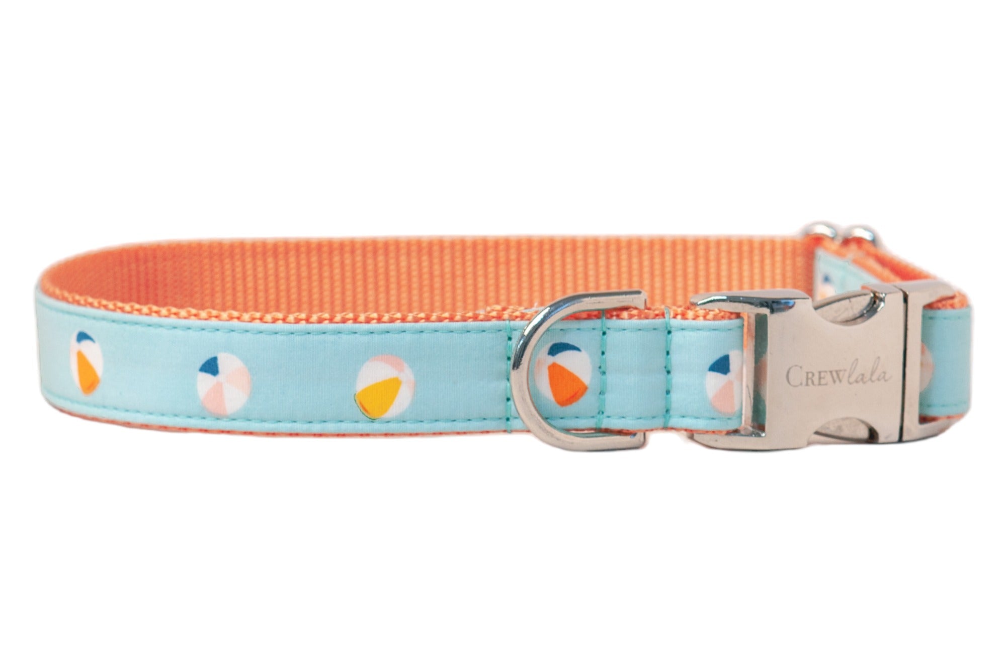 Adjustable dog collar made with orange woven webbing with a light blue patterned fabric overlay featuring a repeating beach ball motif. The collar includes reinforced stitching, a polished metal clasp with engraved branding, and a curved silver D-ring for leash attachment.