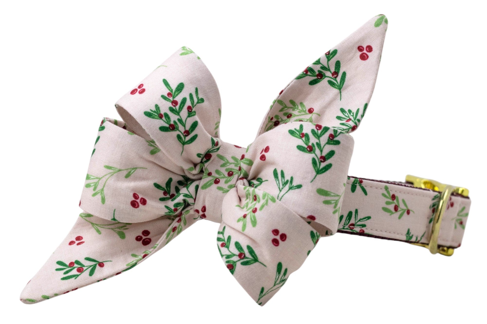 A festive dog collar featuring a dramatic oversized belle bow attachment, both in blush pink fabric with branches and berries. The bow has elongated tails and pleated loops for volume, while the collar itself includes adjustable sizing and polished hardware, blending style and function.