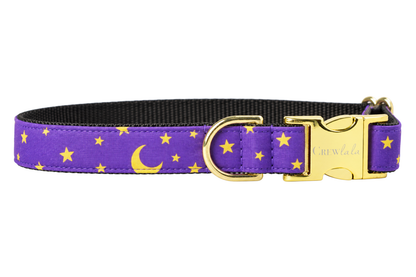 Plain Bewitched dog collar without the bow, made with a purple fabric with golden yellow crescent moons and small stars, lined with black nylon webbing and gold hardware with a Crewlala logo buckle.