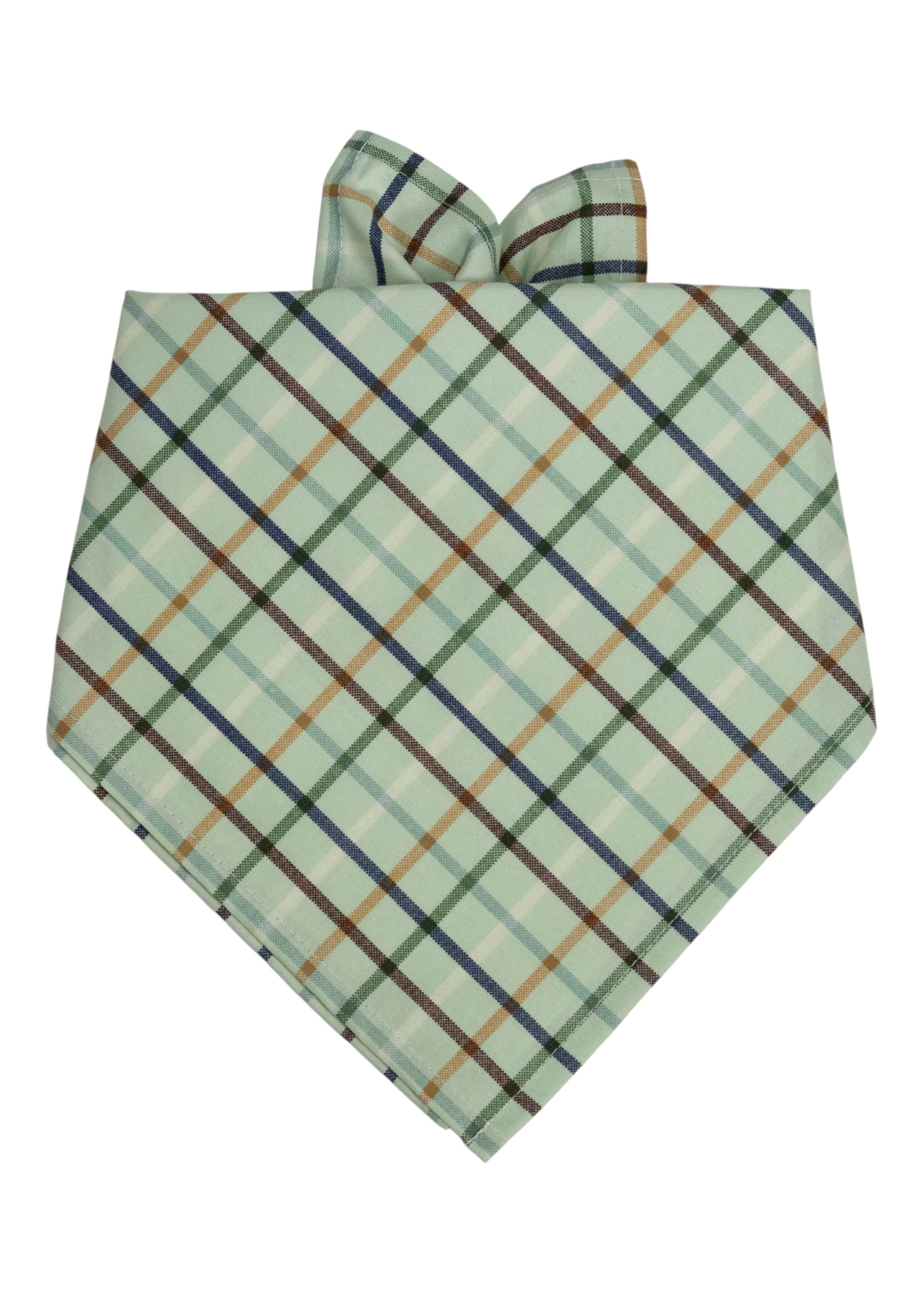 Dog bandana in a soft green plaid fabric with diagonal stripes in navy, gold, brown, and forest green, folded into a triangular shape for tying.