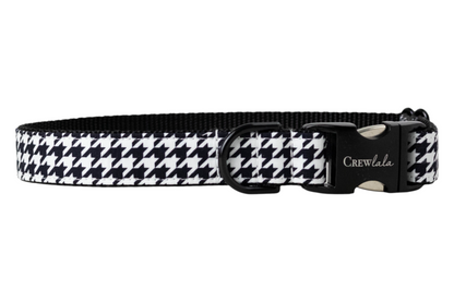 A dog collar with a classic black and white houndstooth pattern on the outer band and a solid black woven interior. The collar features a black metal side-release buckle engraved with the brand “Crew LaLa” and a black D-ring for leash attachment.
