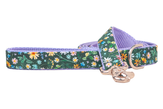 Floral dog leash with a whimsical green background covered in tiny multicolored flowers. The underside is made of soft, textured nylon, and the leash is equipped with metal hardware, including a clip and D-ring for easy attachment.