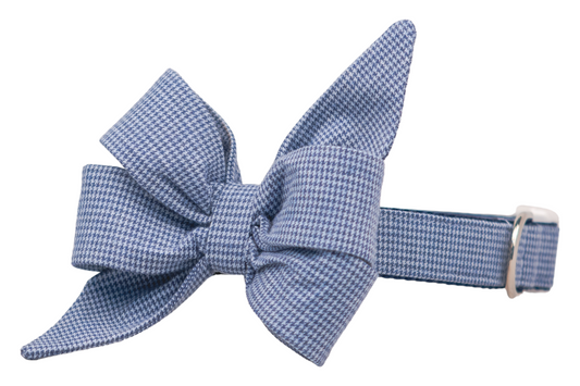Dog collar featuring a dark blue and light blue houndstooth pattern with a large, elegant belle bow in a double-looped style. The collar includes a polished buckle and hardware, adding a refined, dressy touch.