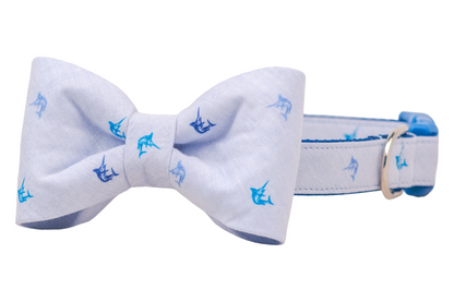 Nautical-themed dog collar and bow tie set in pale blue fabric, decorated with miniature blue marlin fish prints and finished with a vibrant blue buckle and metal d ring.