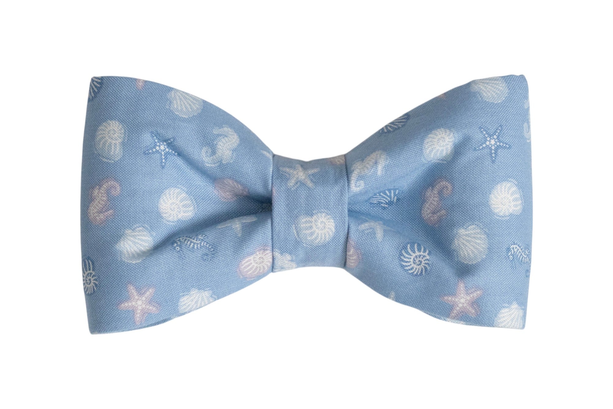 Light blue dog bow tie with a delicate seashell and starfish pattern in soft white and pastel tones.