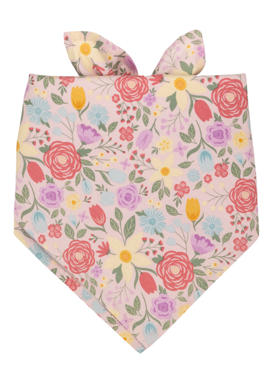 Colorful floral bandana in soft pink fabric, featuring an array of blooming flowers in bright spring shades and leafy green stems. The top is tied into two pointed, bunny ear-style knots.