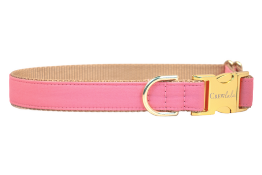 A high-quality bubblegum pink dog collar with tan webbing and reinforced stitching, showcasing a shiny gold buckle clasp engraved with the brand “Crewlala” and a coordinating gold D-ring, blending comfort, charm, and durability for your stylish pup.
