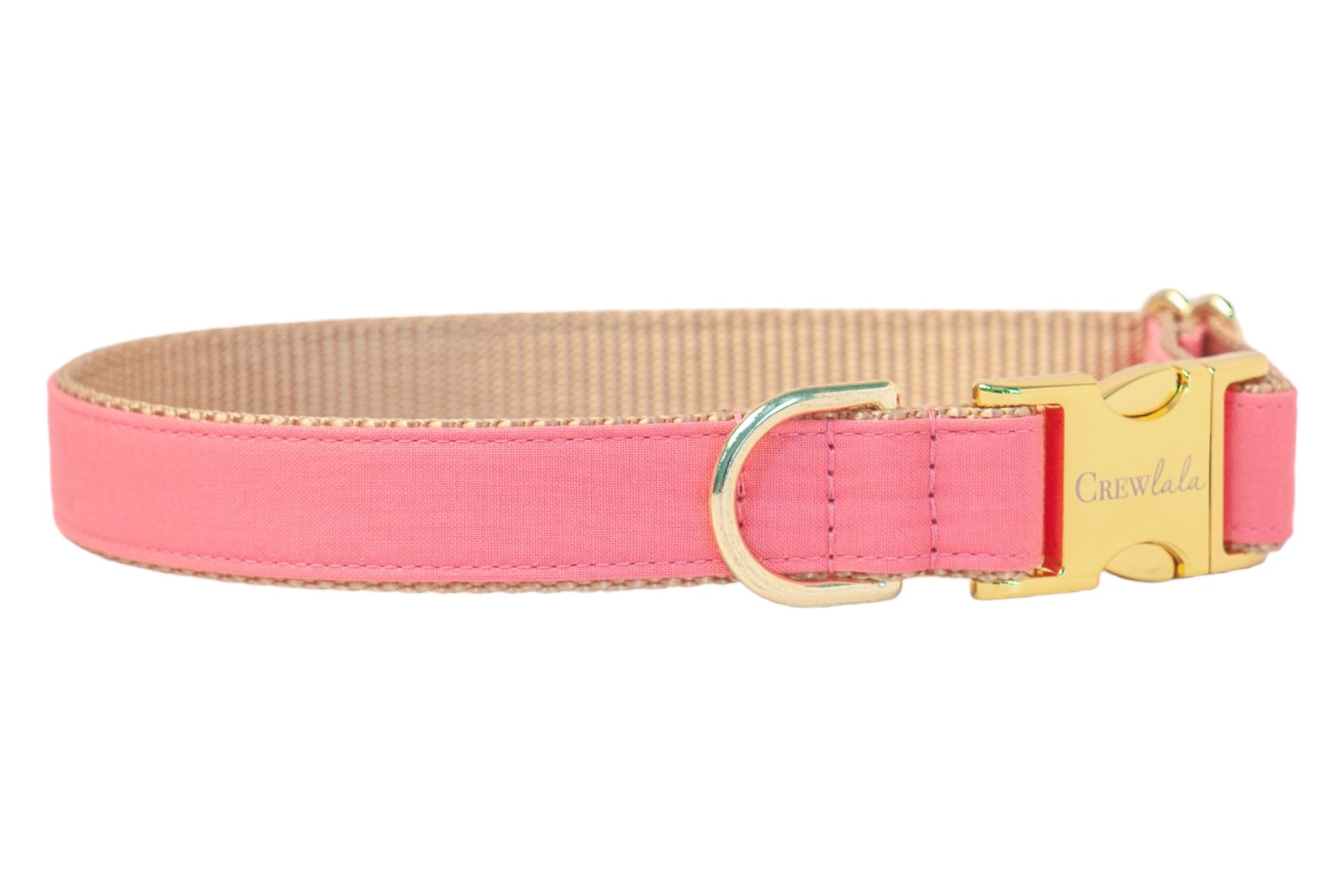 A stylish bubblegum pink dog collar with a tan underside, gold-tone D-ring, and a shiny gold buckle engraved with the brand name “Crewlala,” shown against a white background.