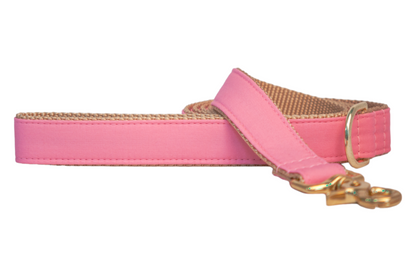 A cheerful bubblegum pink dog leash with a tan woven underside, gold-tone metal clasp, and D-ring, coiled neatly as if ready for a fun walk with your furry friend.