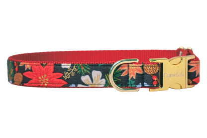 Christmas-inspired dog collar with a deep green background and  bold floral design including poinsettias,  flowers, pinecones, and green foliage. The collar features a contrasting nylon webbing underside and polished hardware, including a D-ring and a glossy side-release buckle etched with “Crew Lala.”