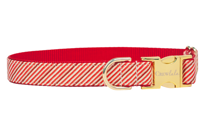 Christmas dog collar made from fabric decorated with diagonal red stripes, think candy canes. The collar includes a sleek buckle engraved with "Crewlala," a D-ring, and red woven lining for comfort and strength, balancing festive flair with everyday use.