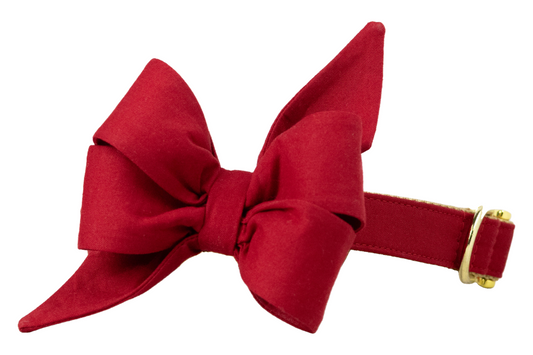 Eye-catching feminine dog collar adorned with an extravagant red bell bow in a multi-looped, flared silhouette, paired with a sleek red band and luxe buckle and D-ring.