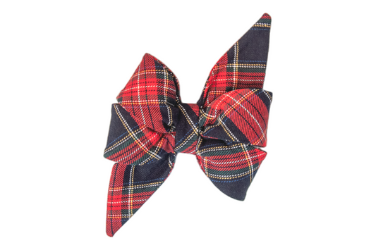 Large, feminine dog belle bow made of soft fabric in a classic red and navy plaid pattern with light stripes. The belle bow has two tall, pointed loops and wide, rounded lower sections for a full and structured shape. 