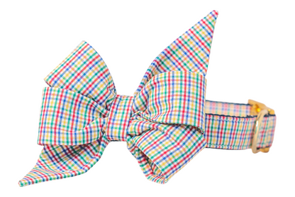 Bright, using primary colors, plaid dog collar with matching oversized belle bow attached. The feminine belle bow has angular shaping with pointed ends and layered folds, while the collar is fitted with a shiny buckle and precise stitching along the edges. Perfect for fall and back to school!