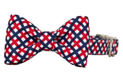 Patriotic-themed dog collar with a decorative bow tie, featuring a red, white, and blue plaid design. The collar includes an adjustable silver buckle for secure fastening.
