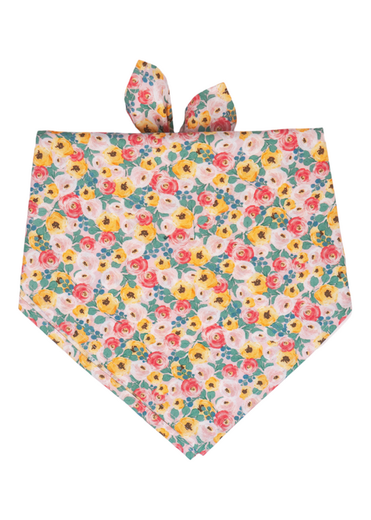 Pastel-toned bandana folded in a triangle shape, featuring an all-over print of watercolor-style roses in warm shades of pink, yellow, and coral with green foliage. Two ear-like knots are tied at the top.