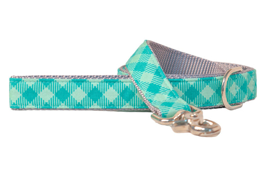 Dog leash in a fresh green plaid pattern with alternating light and dark green diamonds and vertical pinstripes. The leash features a metal D-ring for accessories, and a clasp for attaching to a collar.