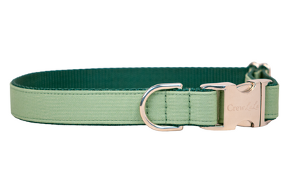 A two-tone green dog collar made of durable fabric, with a light green exterior and a rich forest green interior. It features a sturdy silver buckle engraved with the logo “Crew Lala” and a matching metal D-ring for attaching a leash or ID tags.