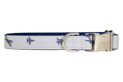 A gray dog collar decorated with navy blue fighter jet silhouettes, lined with navy blue webbing. The collar is equipped with a silver-tone D-ring and a silver buckle.