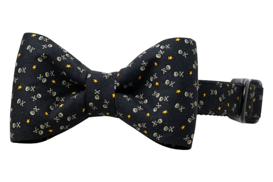 Stylish pet accessory combining a black bow tie and matching collar, both adorned with tiny skull motifs and stars, finished with an adjustable strap and secure black buckle.