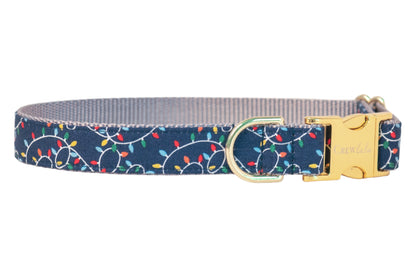 Festive dog collar in navy blue decorated with multicolored holiday lights. Festive bulbs are strung along swirling cords for a cheerful seasonal look. Accented with a metal buckle and hardware.