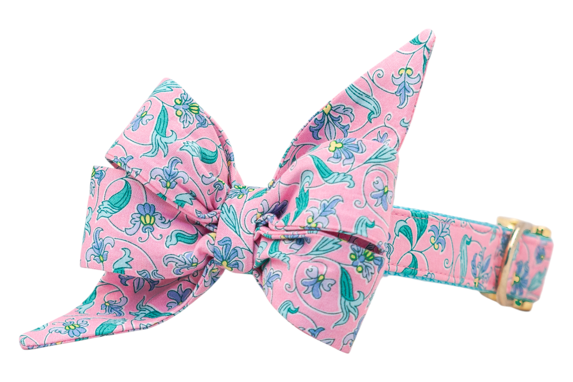 Dog collar with an oversized belle bow for your favorite gal, made of pink fabric adorned with an intricate floral pattern in purple, teal, and yellow. The design includes swirling leaves and blooming flowers, with the bow dramatically tied and secured to a matching dog collar with gold-tone metal hardware.