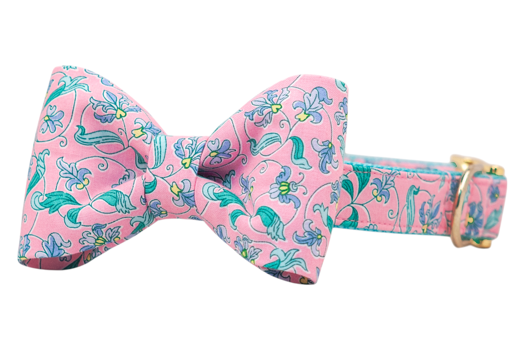 Chic dog collar featuring a bow tie made from pink fabric adorned with swirling green stems and pastel flowers. Gold hardware accents the collar, creating a stylish and spring-inspired pet accessory.