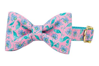 Classic dog collar featuring a Garden Gate fabric bow tie, a pink print with teal and periwinkle blue flowers and vines, attached to a matching Garden Gate collar with a nylon inner lining and gleaming gold hardware, including a D-ring and buckle.