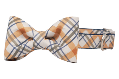 Stylish dog collar featuring a neat bow tie in a fall-toned plaid print. The fabric has a crisp, tailored appearance, and the collar includes a metal loop for added functionality.