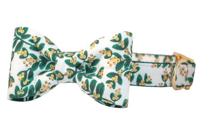Festive dog collar with a matching bow tie, featuring a light background with green foliage and metallic berries, paired with polished hardware for a merry, picture-ready vibe.