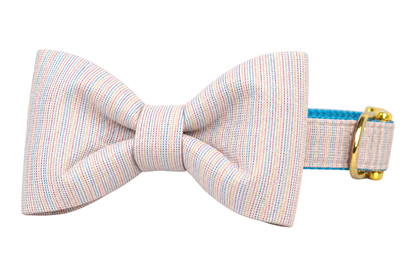 Classic dog collar featuring a Gotcha Glitter fabric bow tie, a pale cream and blush fabric woven with fine pastel rainbow pinstripes and a subtle shimmer, attached to a matching Gotcha Glitter collar with a nylon inner lining and gleaming gold hardware, including a D-ring and buckle.