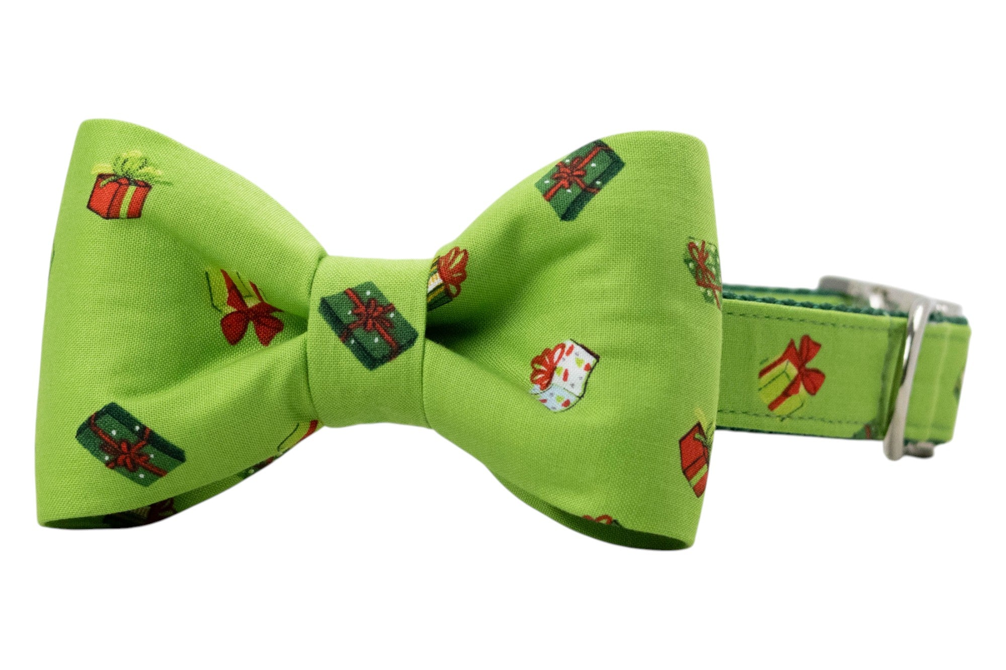 Festive dog collar with an attached bow tie, crafted from green fabric covered in small, vibrant gift illustrations. The bow tie has a traditional shape with a gathered center, while the matching collar is secured with metal hardware for easy adjustment.
