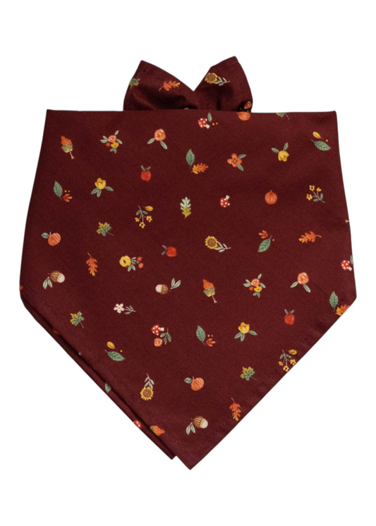 Autumn-themed dog bandana in a rich burgundy color, covered in small illustrations of fall elements like pumpkins, sunflowers, oak leaves, and forest berries.