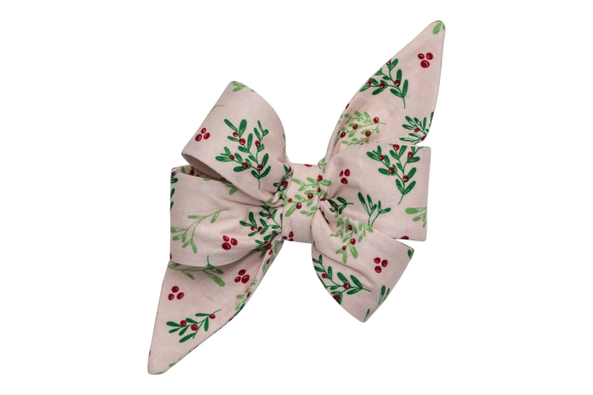 A handcrafted dog belle bow made from pink fabric patterned with leafy branches and berries. The design includes full loops and long tails that taper to points, forming a classic, oversized bow shape. It is intended as a collar accessory, adding a festive or botanical touch to a pet's look.