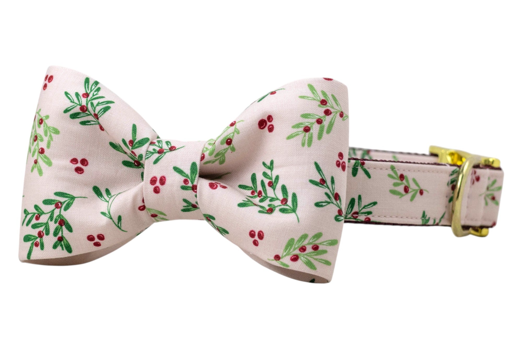 Festive dog collar with a matching bow tie, crafted from pale pink fabric decorated with clusters of berries and leaves. The bow tie is large and symmetrical, attached directly onto the collar. The collar includes shiny hardware, such as a D-ring and an adjustable clasp for sizing.