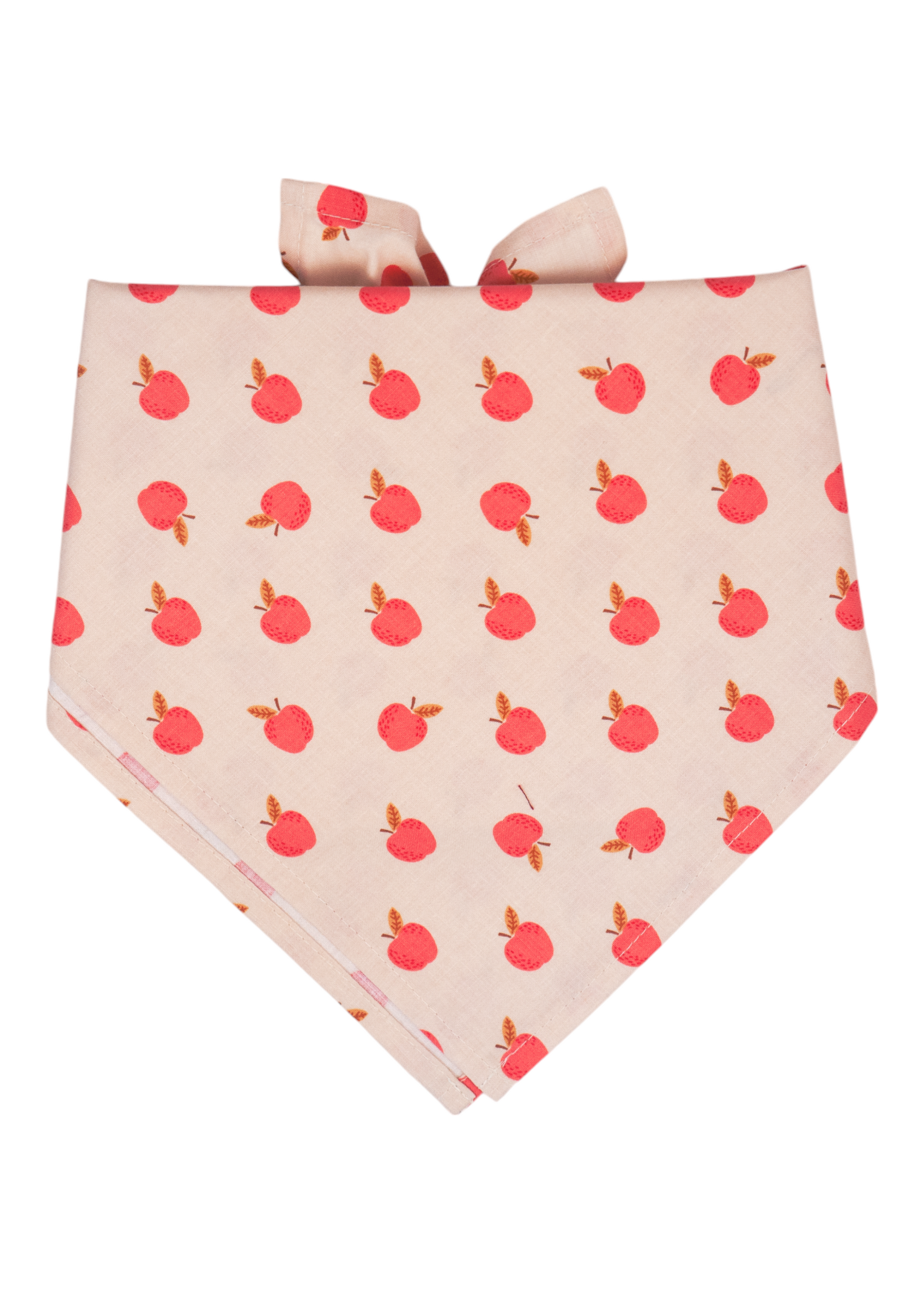 A cream-colored dog bandana with an all-over print of small red apples with leaves, folded into a triangle shape and tied at the top. Handmade in Charleston, SC.