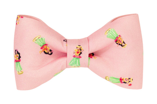 Cute pink fabric dog bow tie featuring a repeating pattern of cheerful hula girls dancing in bright tropical outfits.