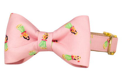 Cute pink collar with a neatly tied matching bow tie, printed with cheerful hula girls dancing in colorful Hawaiian outfits.