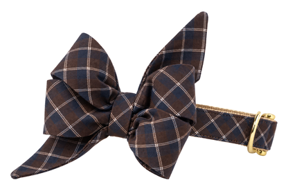 Dog collar featuring a large belle bow in Hunt Club fabric, a dark chocolate brown fabric with a thin tan and slate blue windowpane check, attached to a matching Hunt Club collar with a nylon inner lining and gleaming gold hardware, including a D-ring and buckle.