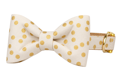 Classic dog collar featuring a Ivory Party Dot fabric bow tie, an ivory cream fabric with scattered metallic gold dots, attached to a matching Ivory Party Dot collar with a nylon inner lining and gleaming gold hardware, including a D-ring and buckle.