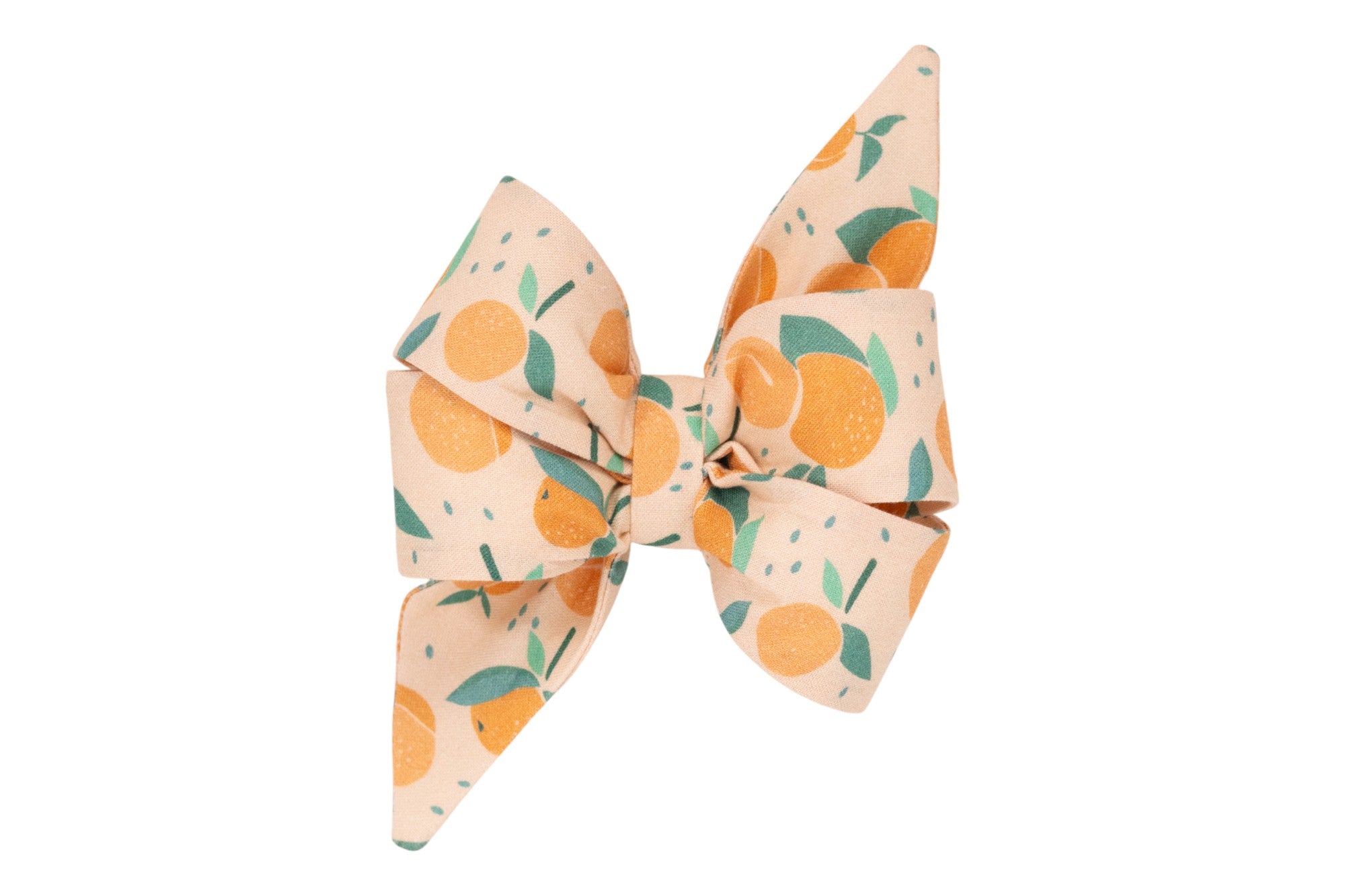 A decorative dog bow with pointed tails, made from peach-colored fabric printed with bright peaches, green leaves, and scattered seeds.