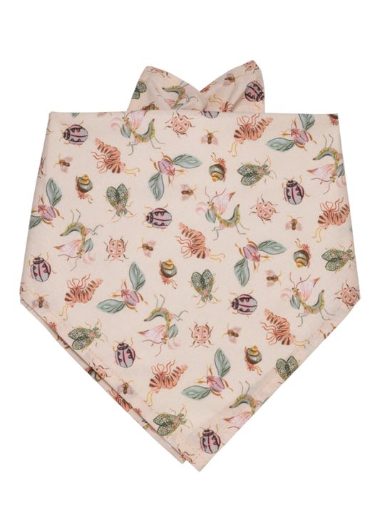 Whimsical dog bandana featuring a playful print of colorful bugs and blossoms on a soft pink background—perfect for pups with a flair for fashion and fun.