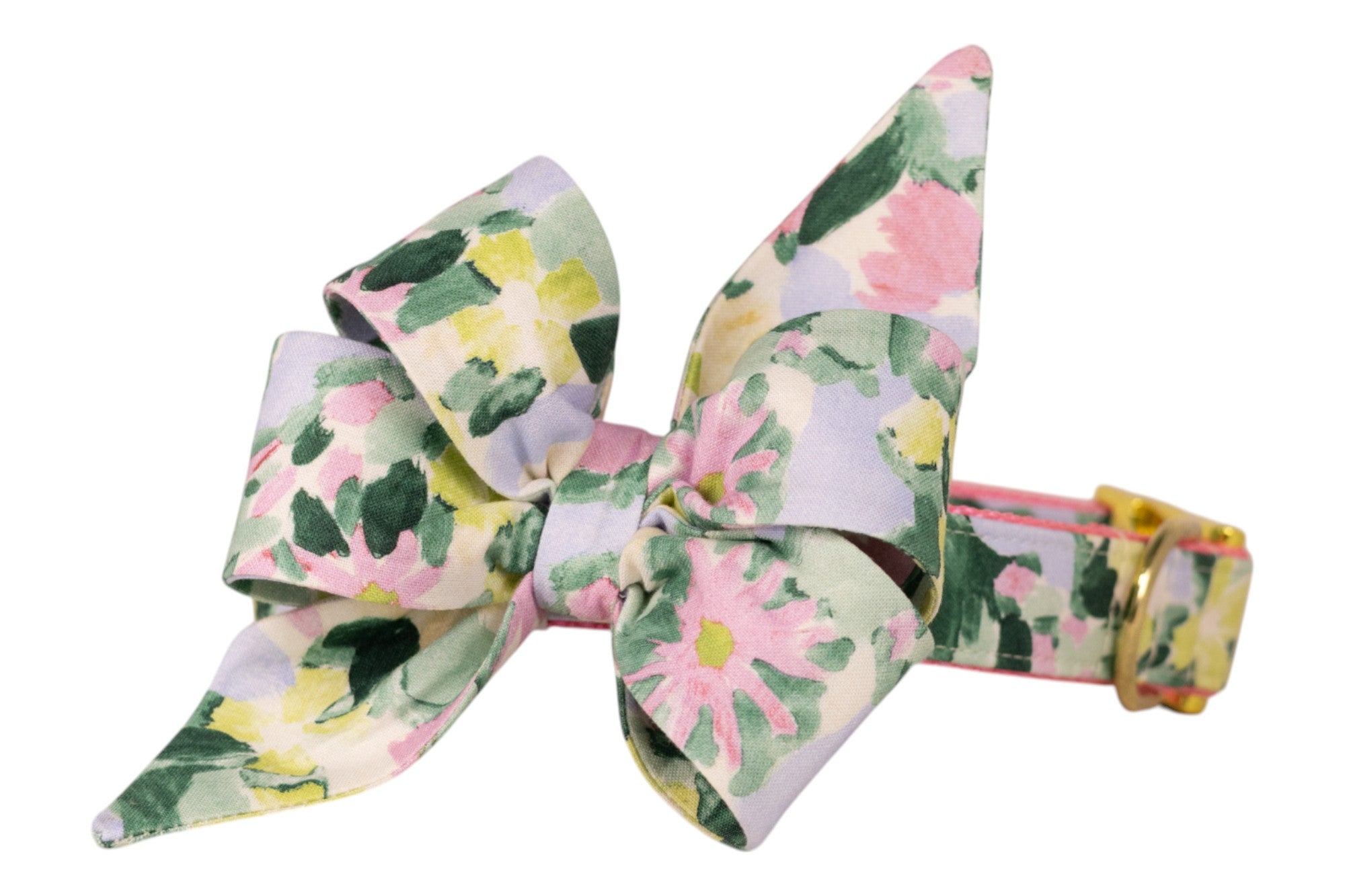 Decorative dog collar with a large pointed bow in a pastel floral fabric, showcasing soft pink flowers, leafy greens, and yellow blooms, paired with gold hardware.