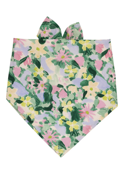 Floral-patterned dog bandana in a painterly design with pastel blooms and foliage in soft green, pink, and yellow tones, styled with small ear-like ties at the top.